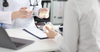 Doktor, klinikteki hastaya silikon göğüs implantı gösterdi. Göğüs büyütme ve kaldırma kavramı