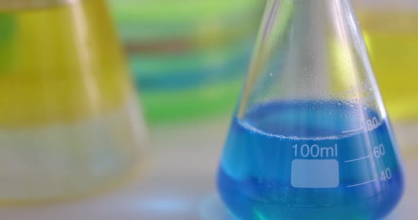 Фляжки Синей Желтой Жидкостью Стоящие Столе Химической Лаборатории Крупным Планом — стоковое видео