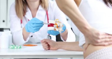 Doktor 4K filminde hasta hastaların önünde plastik omurga modelinde fıtık gösteriyor. Omurga konsepti ile nörolojik sorunların teşhisi ve tedavisi