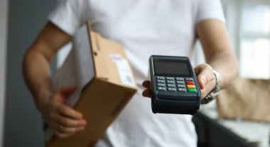 Erkek teslimatçı Pos terminalini yakın plan çekimde tutuyor. Hızlı teslimat postası kurye hizmeti konsepti, çevrimiçi alışveriş mağazası.