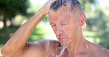 Duşun altında duran bir adamın portresi ya da serin akıntıdan hoşlanan bir adam. Yakışıklı bir adam ve yaz duşunda üşüyor.