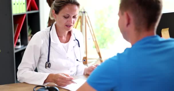 Γυναίκα Γιατρός Ελέγχει Την Υγεία Των Ασθενών Και Εξηγεί Την — Αρχείο Βίντεο