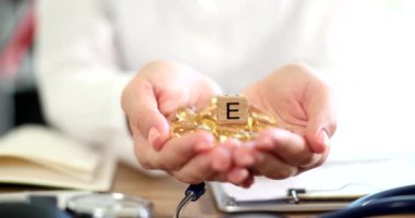 Doktor elinde vitamin ve balık yağı kapsülleri var. Vitaminler cilt sağlığı için iyidir.