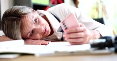 Akıllı telefon kullanan ve doktor ofisinde mesaj atan endişeli bir tıp doktoru. Yorgunluk depresyon stresi ve tıbbi terapist