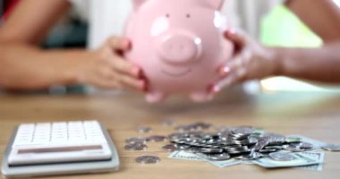 Domuz kumbarası dolusu para ve hesap makinesi. Finansal bütçe depozitosu ve tasarruflarda kârlı yatırım