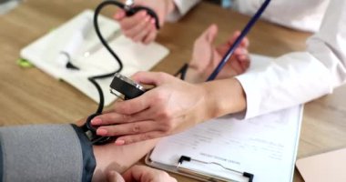 Doktor klinikteki hastanın kan basıncını ölçüyor. Yüksek tansiyon, aşama semptomlarına neden olur.