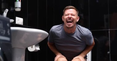 Tuvaletteki hemoroitten muzdarip bir adam. İshal kabızlık ve bağırsak problemi.