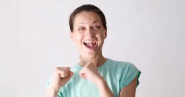 Çekici, güzel bir kadın neşeyle gülümser ve dans eder. Başarı duyguları ve olumlu ruh hali.