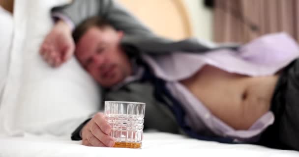眠っているビジネスマンは ホテルの部屋でベッドで眠り アルコールを保持します アルコール乱用の概念うつ病ストレスとアルコール依存症 — ストック動画