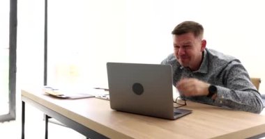 Gözlüklü bir iş adamı dizüstü bilgisayar 4K filminde gözlerini kısarak bağırıyor. Kötü iş haberleri çevrimiçi kavramı