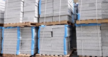 Yığılmış taş kaldırım levhaları, ahşap tepsilerde, 4 km 'lik ağır çekimde yatıyor. İnşaat malzemeleri konsepti satışı