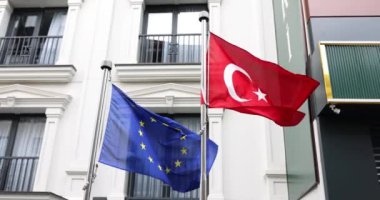 Türk ve Avrupa Birliği bayrakları, büyükelçiliğin 4K filminde ağır çekimde dalgalanan rüzgarda dalgalanıyor. Ülkelerin uluslararası etkileşimleri ve yararlı işbirliği kavramı