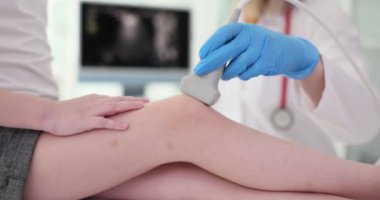 Doktor pediyatrist, klinikte çocuğun diz eklemlerini ultrason muayenesi yapıyor. Çocuk konseptinde romatizma hastalıklarının teşhisi