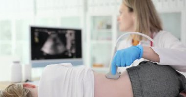 Çocuk doktoru doktor, çocuk böbreklerinin ultrason muayenesini klinik 4K filminde ağır çekimde yapıyor. Çocuk konseptinde hastalıkların ve üreme sisteminin enstrümantal teşhisi