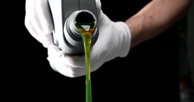 Usta tamirci araba motoruna makine yağı döküyor. 4K film yavaş çekimde kapanıyor. Araba bakım motoru yağ değişimi kavramı