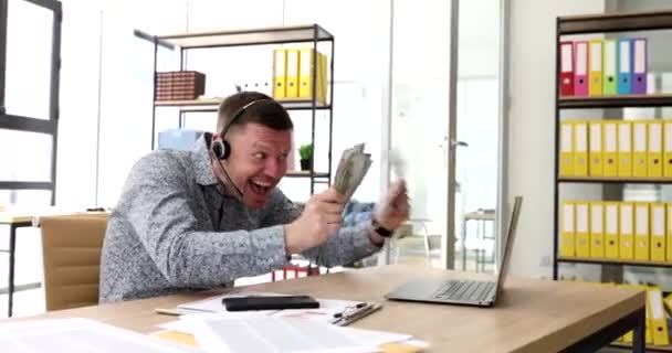お金を誇るマイクとノートパソコン4K映画の画面に舌を示すヘッドセットのビジネスブロガー 詐欺ビジネスオンラインブログの概念 — ストック動画