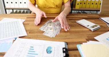 Ofisteki kadın masadaki dolarları sayıyor, yakın plan. Maaş ve ikramiye çalışanı, yavaş çekim