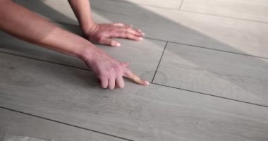 Yakın plan, kadın elleri laminata leke sürerken yerde. Ofis temizliği, yerde ahşap kaplama.