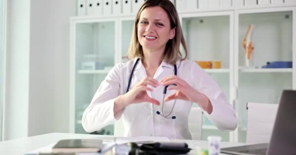Médico Sonriente Clínica Muestra Signo Del Corazón Primer Plano Personal — Vídeos de Stock
