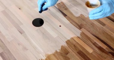 Marangoz ahşap kaplamalı cila sürüyor. Parke onarımı, doku, yavaş çekim