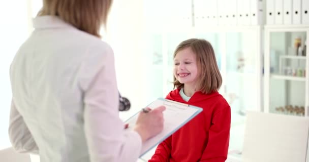 소녀는 의사를 가까이 쳐다본다 의사는 아이의 증상을 알게될 것입니다 — 비디오