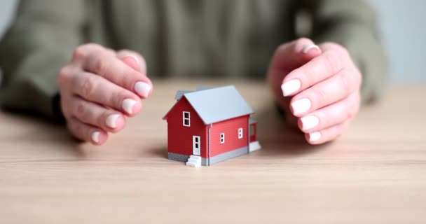 Hände Schließen Das Modell Des Roten Hauses Auf Dem Tisch — Stockvideo
