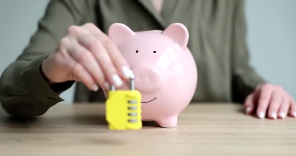 テーブルの上に暗号とピンクの貯金箱を持つ黄色の城 クローズアップ 銀行の概念預金 — ストック動画