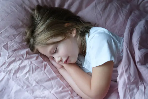Little girl sleeping in pink bed at home. Healthy sleep for children concept