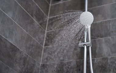 Banyodaki duş başlığından akan su damlaları. Banyo eşyaları konsepti satışı.