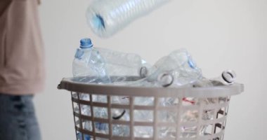 Elle plastik şişeyi çöp kutusuna atmak. Yakın çekim 4K film yavaş çekim. Atık toplama kavramını ayır