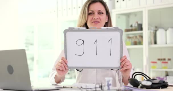 Médico Sosteniendo Cartel Con Número Teléfono 911 Clínica Película Cámara — Vídeos de Stock