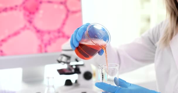 科学家化学家将橙汁倒入实验室的瓶中 密闭4K膜慢动作 制药企业药品生产概念 — 图库视频影像
