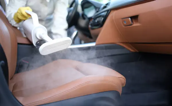 Steam cleaning and disinfection of car interiors and car seats with steam cleaner. Car interior cleaning concept