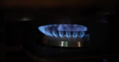 Cooking gas stove and electric stove on dark background. Burning gas stove with flame. Gas crisis and increase in cost of gas concept