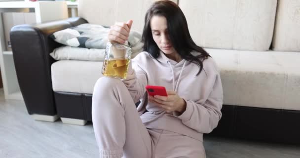 Kvinna Med Flaska Alkohol Och Smartphone Sitter Golvet Fylld Korrespondens — Stockvideo
