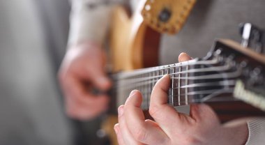 Erkek tutan ve oyun klasik şekli ahşap elektro gitar closeup silah. Altı Müzik Okulu eğitim sanat eğlence elektrik vintage sahne Dükkanı eğleniyor öğrenme yaylı hobi kavramı keyfi