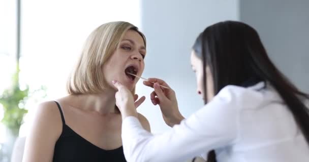 家庭用4K映画で女性患者の喉を調べる医師 季節の寒さの概念 — ストック動画
