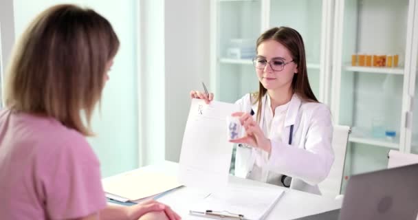 Νεαρός Οικογενειακός Γιατρός Δίνει Σχέδιο Θεραπείας Και Ένα Μπουκάλι Χάπια — Αρχείο Βίντεο