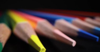 Siyah arka planda çok renkli sivri uçlu kalem uçları. Çocuklar ve yetişkinler için çizim ve öğrenim amaçlı kırtasiye malzemesi. Sanatçı konsepti aracı