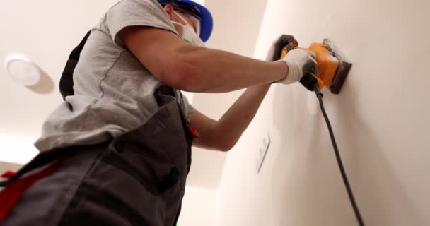 Mężczyzna Budowniczy Respiratorem Wykorzystuje Polerkę Elektryczną Mielenia Ścian Jasnym Płaskim — Wideo stockowe