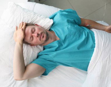 Kendi kendine tedavi zarar verme konsepti. Adam uzun süre doktorlara gitmemiş ve yoğun bakıma alınmış. Hasta yatağında yatıyor ve acı çekiyor.