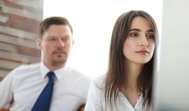 Bilgisayar ekranına bakan iki iş arkadaşı bir şeyin vesikalığını analiz ediyor.