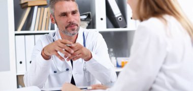 Yakışıklı olgun doktor gülümseyen gümüş kalem tutan hasta ile iletişim kurmak ve yastık. Fiziksel sözleşmesi imza hastalık önleme onay işareti 911'i çare sağlıklı yaşam konsepti reçete