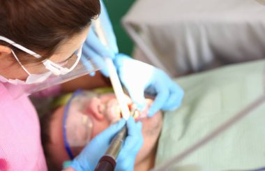 Mavi koruyucu eldiven El profesyonel ağız hijyeni closeup yürütmektedir. Kabul edilmek için diş hekimi hastaya sağlık sigortası kavramı için klinik ödeme ödenmiş