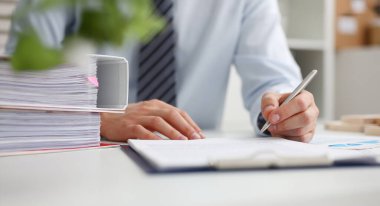 Gümüş kalem açılan Not Defteri sayfasına Not yapmaya hazır tutan erkek el. Çalışma alanı, takım elbiseli işadamı yapmak düşünceler kayıtları özel tertipçi beyaz yakalı konferans imza kavramı