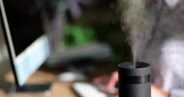 Ofiste çalışan müdürün geçmişine karşı nemlendirici çalışıyor. Sağlıklı ofis ortamı ve nemlendirici buhar