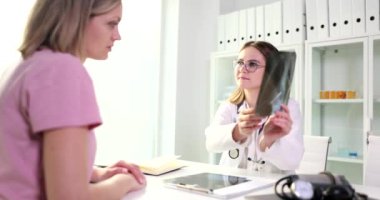 Terapist, klinikteki hastaya röntgen gösteriyor. Kadınlara akciğer muayenesi sonuçlarını açıklayan terapist