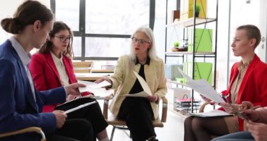 Yaşlı olgun kadın Seo takım lideri koçu, çalışanlara grup toplantısında kağıt işleri planını açıklamayı öğretiyor. Danışman, şirket ofisindeki atölyede çeşitli personelleri eğitir.