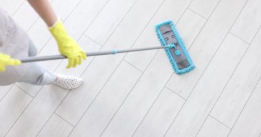 Hizmetçi paspası tutarken yerleri yıkıyor. Temizlik servisi