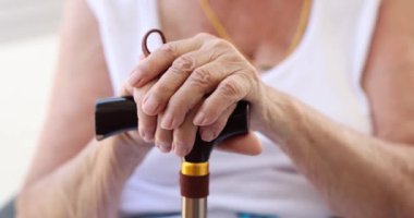 Yalnız, olgun bir kadın baston tutuyor. Üzgün ve bunalımda olan yaşlı büyükannem emekli oldu ve sağlık sorunları yaşıyor.